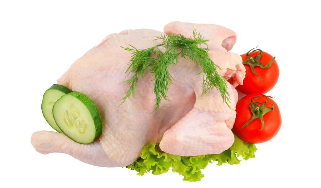 Сырая курица с помидорами, огурцами и листьями салата