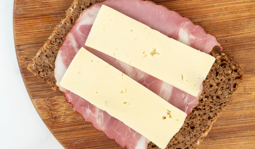Бутерброд с ветчиной и сыром на доске 