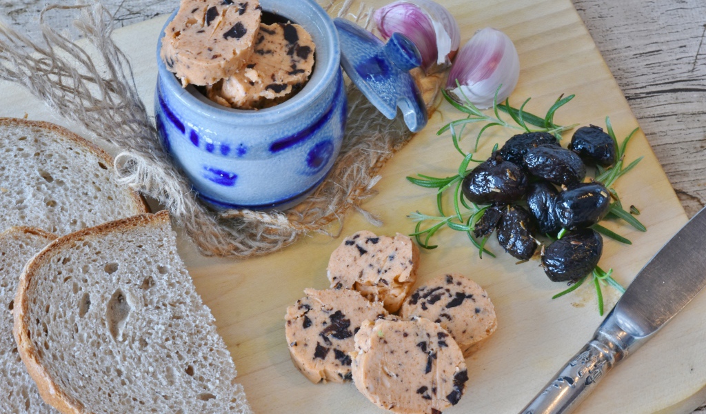 Колбаса с маслинами на столе с хлебом и чесноком