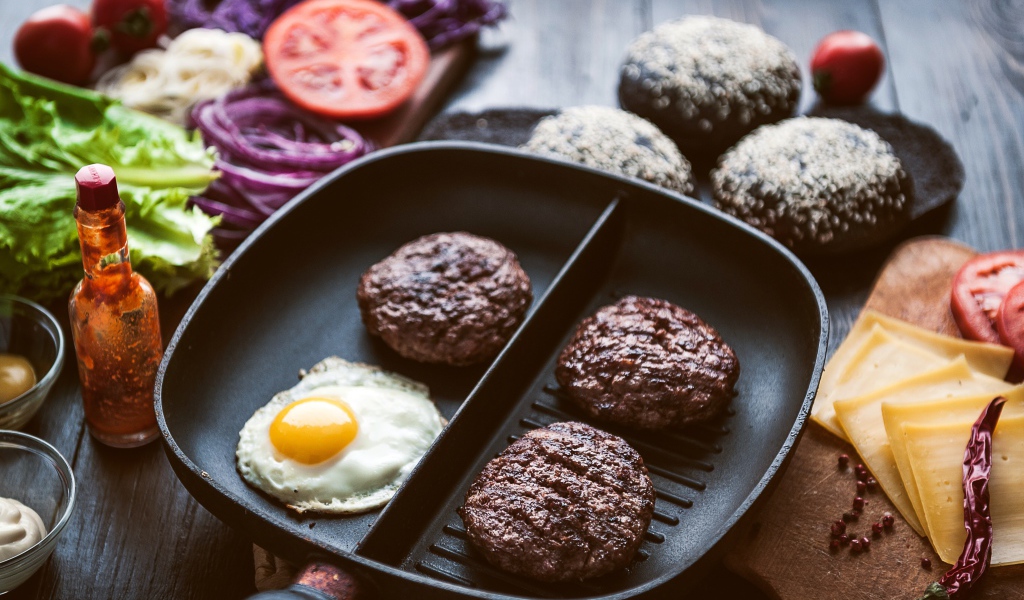 Три котлеты на сковородке с яичницей