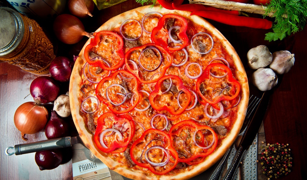 Большая пицца с мясом, луком и болгарским перцем на столе 