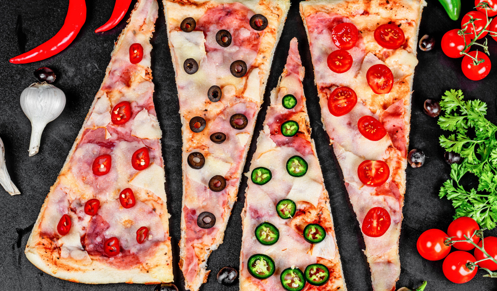Четыре куска аппетитной пиццы с ветчиной и острым перцем