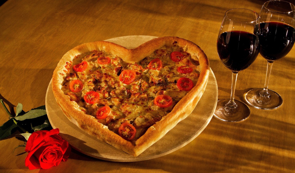 Пицца в форме сердца на столе с розой и двумя бокалами вина