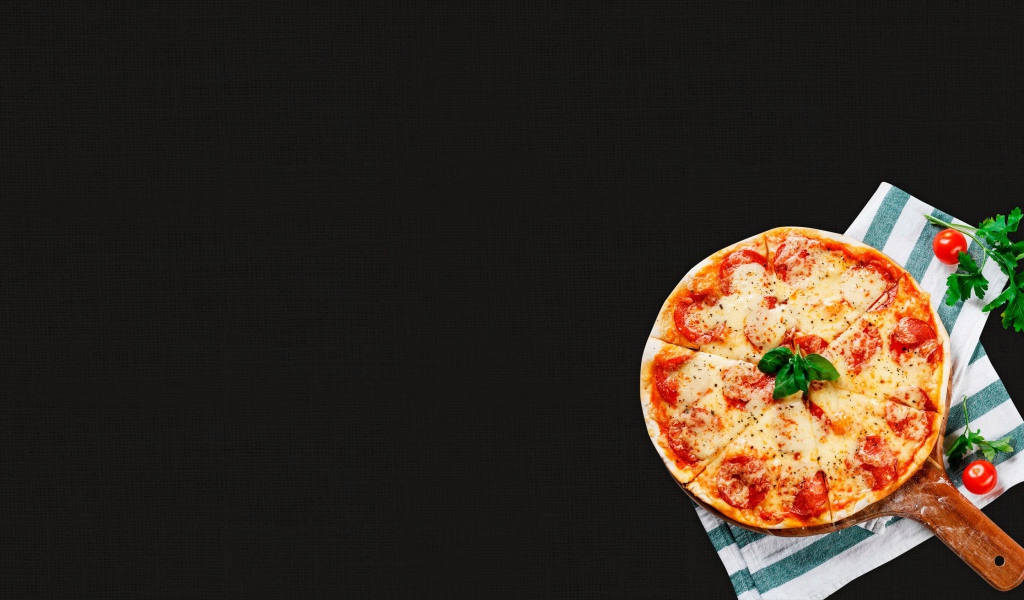 Пицца с колбасой и сыром на столе с полотенцами 