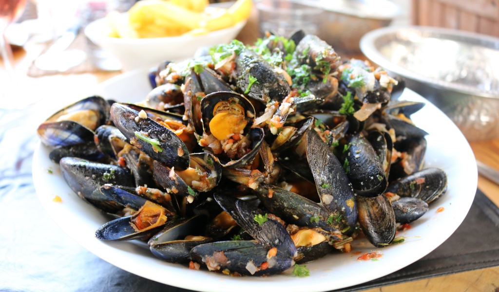 Мидии на  белой тарелке со специями 