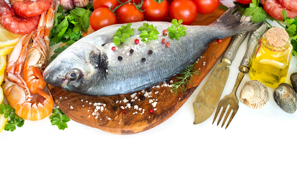 Сырая рыба на столе с маслом и помидорами 