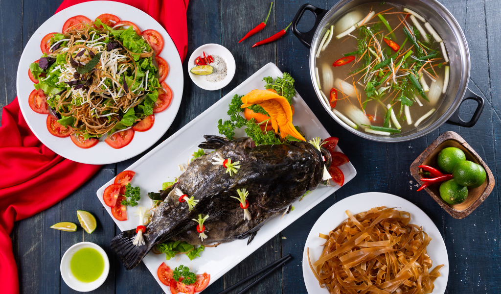 Фаршированная рыба на столе с овощами