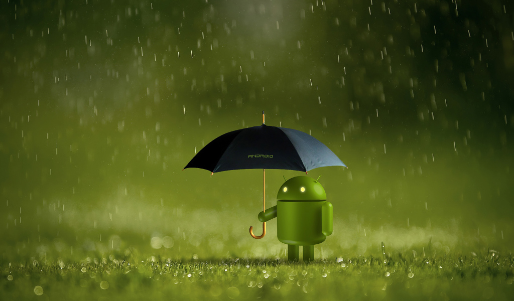 Зеленый Android стоит на траве под зонтом