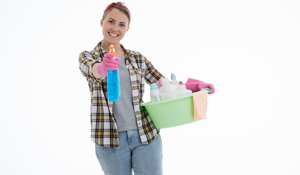 Девушка домохозяйка делает уборку на белом фоне