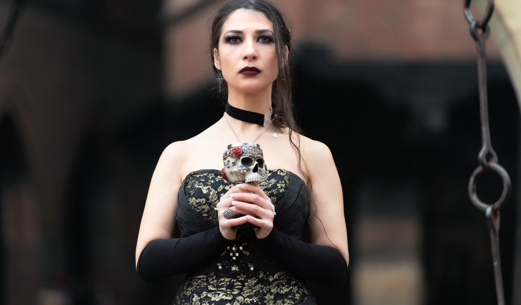 Девушка готка с бокалом - черепом в руках 