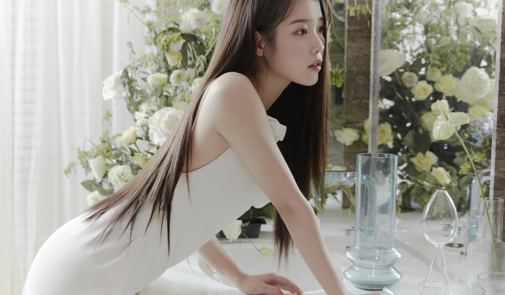 Красивая девушка азиатка в белом платье стоит у зеркала