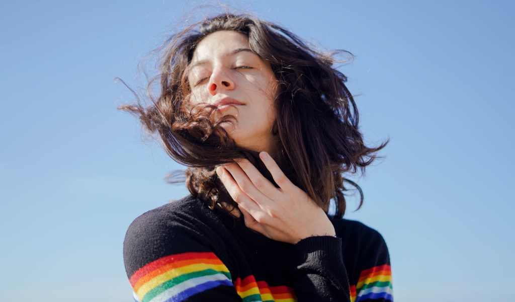 Молодая девушка греет лицо на солнце