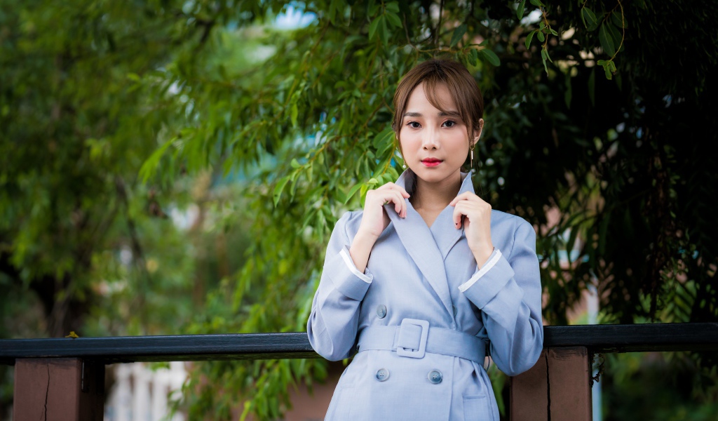 Девушка азиатка в голубом пальто в парке