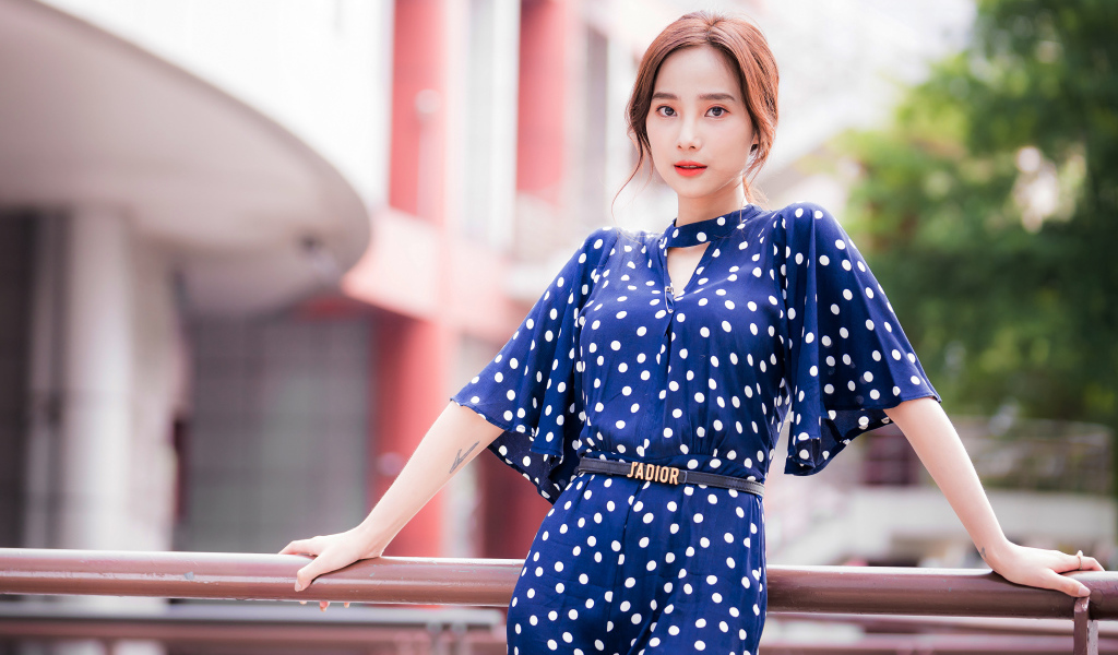 Девушка азиатка в синем платье в белый горошек
