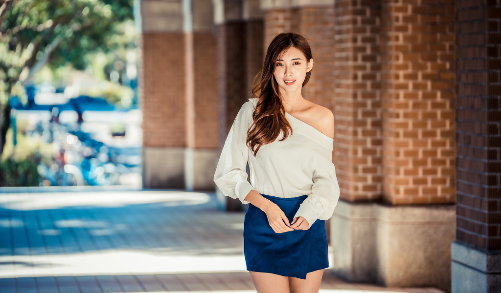 Девушка азиатка в короткой юбке у стены