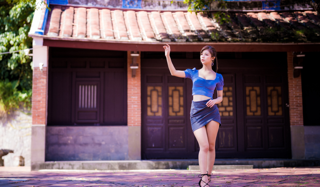 Девушка азиатка в короткой юбке у здания 