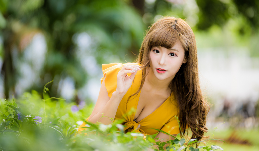 Девушка азиатка в желтом платье в парке 