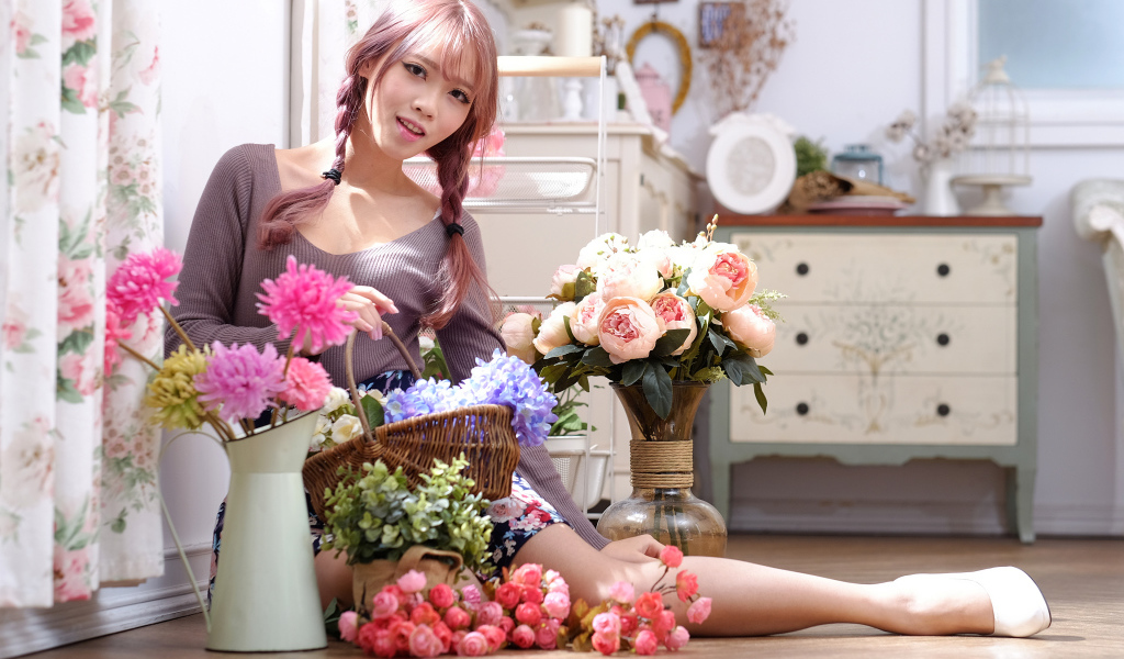 Девушка азиатка сидит с цветами на полу у окна