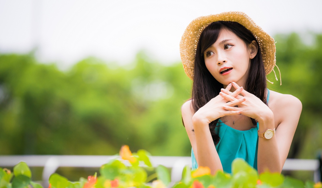 Девушка азиатка с часами на руке в шляпе