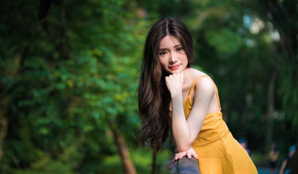 Девушка азиатка с большими карими глазами в желтом платье 