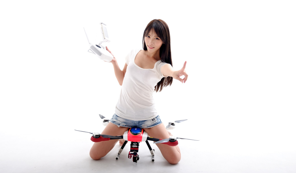 Девушка азиатка с квадрокоптером на белом фоне