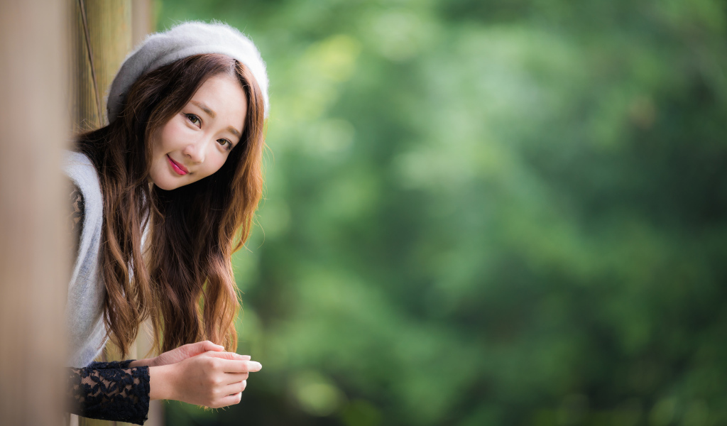 Азиатка в берете выглядывает из окна