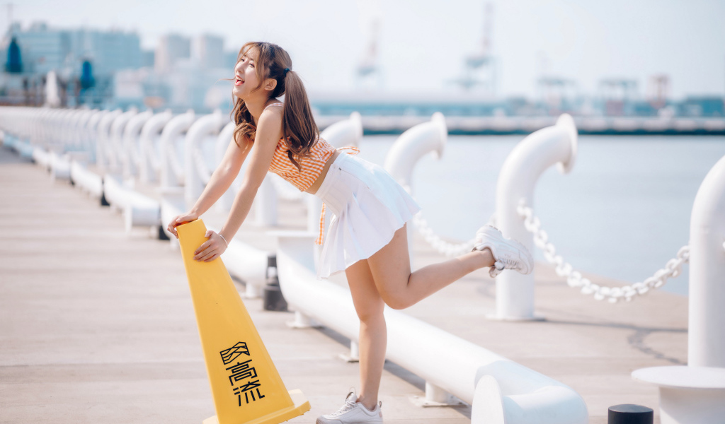 Азиатка с короткой белой юбке у воды 