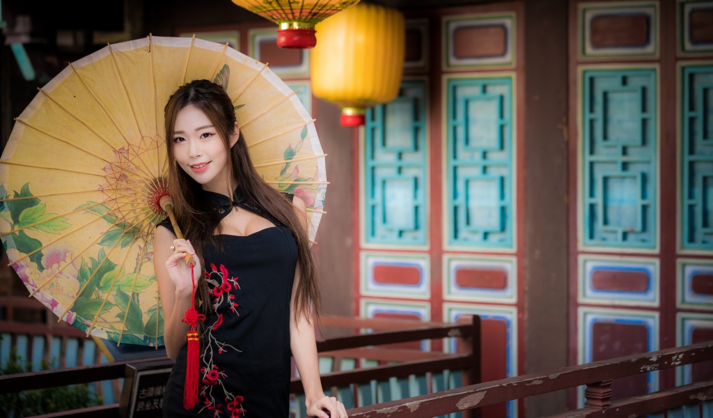 Красивая девушка азиатка в черном платье с зонтом