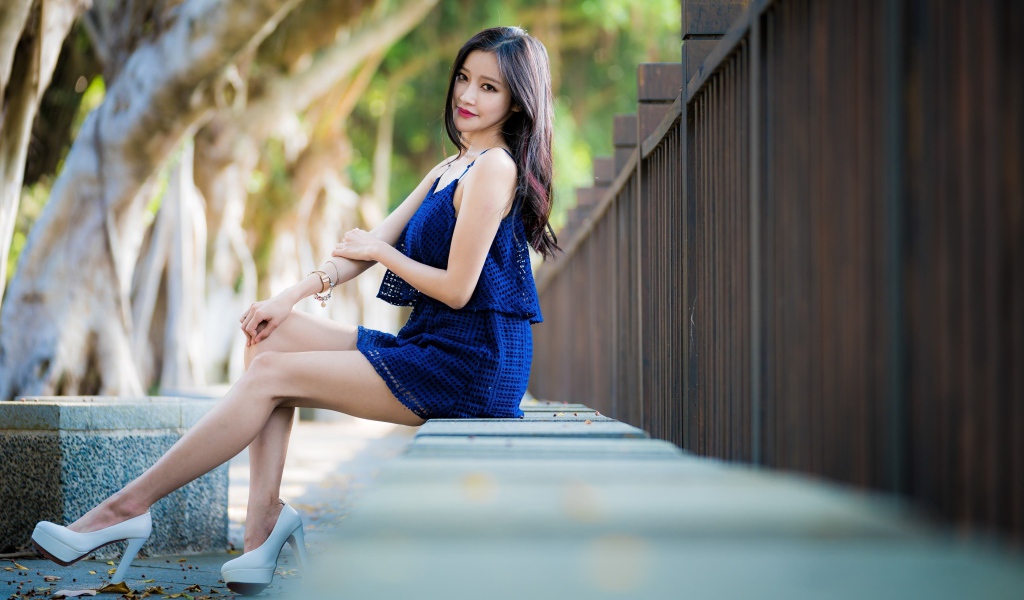 Красивая девушка азиатка в синем платье в парке