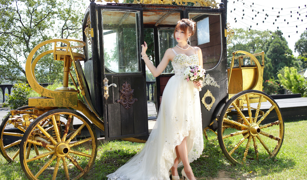 Красивая девушка азиатка в свадебном платье у кареты 