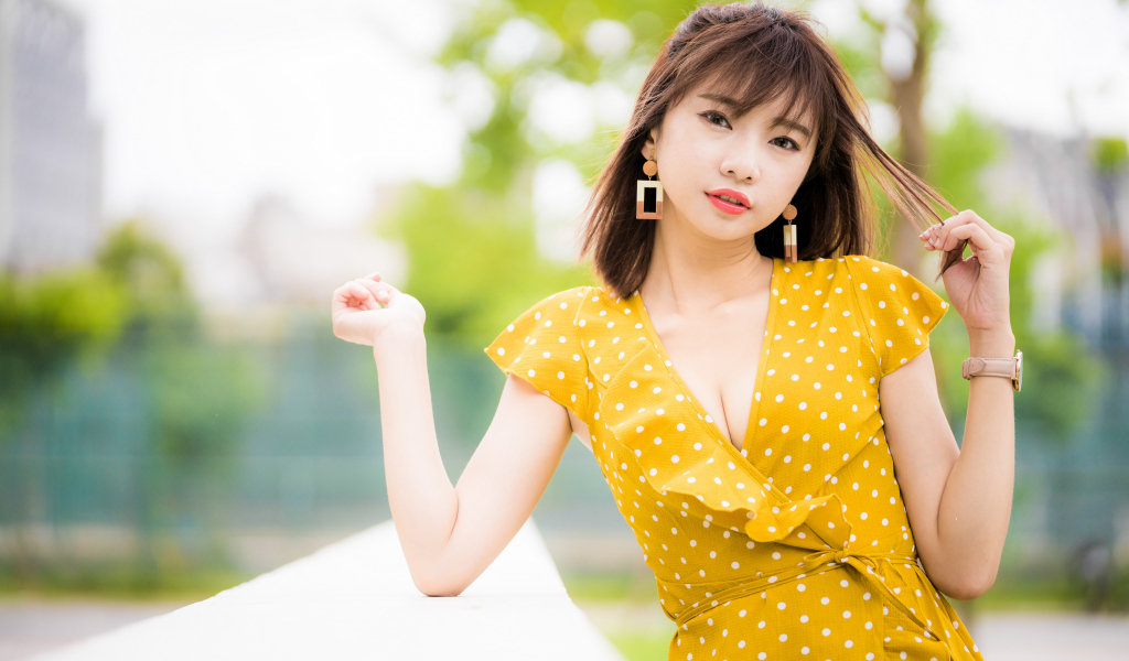 Красивая азиатка в желтом платье в белый горох 