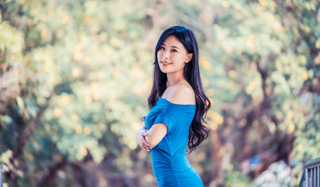 Красивая девушка азиатка с милой улыбкой в голубом платье 