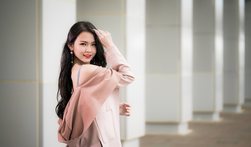 Красивая девушка азиатка с длинными волосами в розовом пальто 