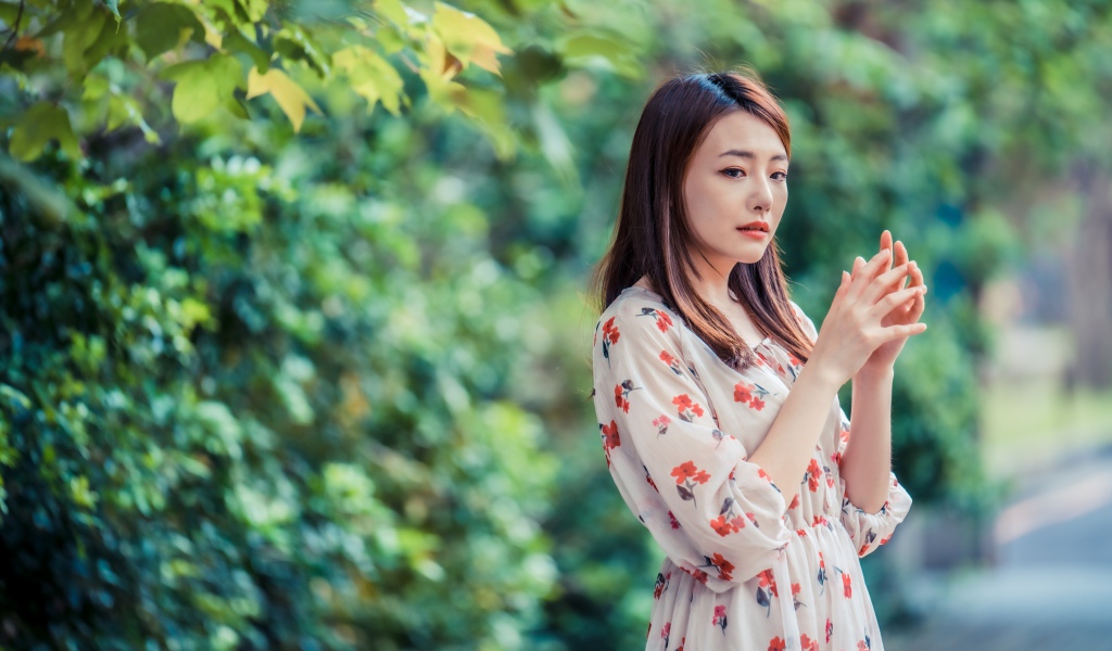 Красивая девушка азиатка в платье в парке