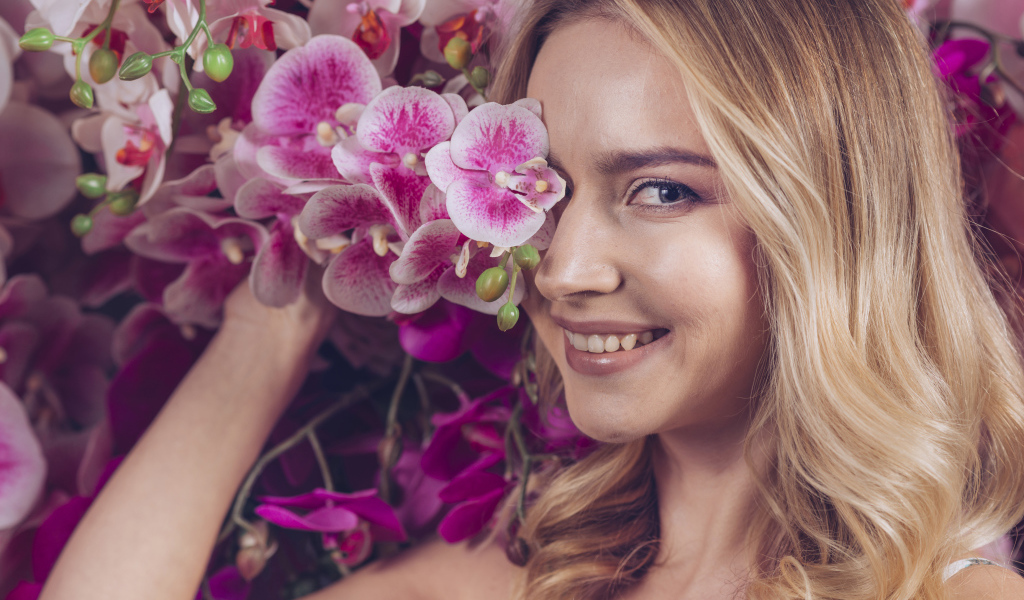 Красивая девушка блондинка с цветами орхидеи
