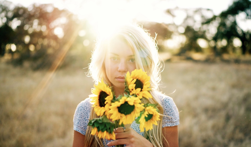 Красивая блондинка с букетом подсолнухов в руках