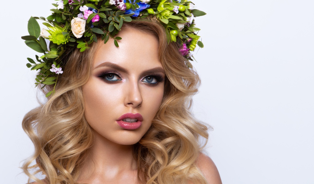 Красивая блондинка с венком из живых цветов на белом фоне