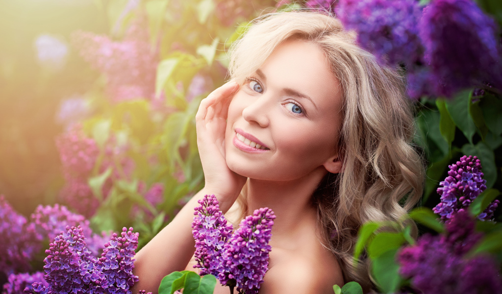 Красивая голубоглазая девушка блондинка в цветах сирени