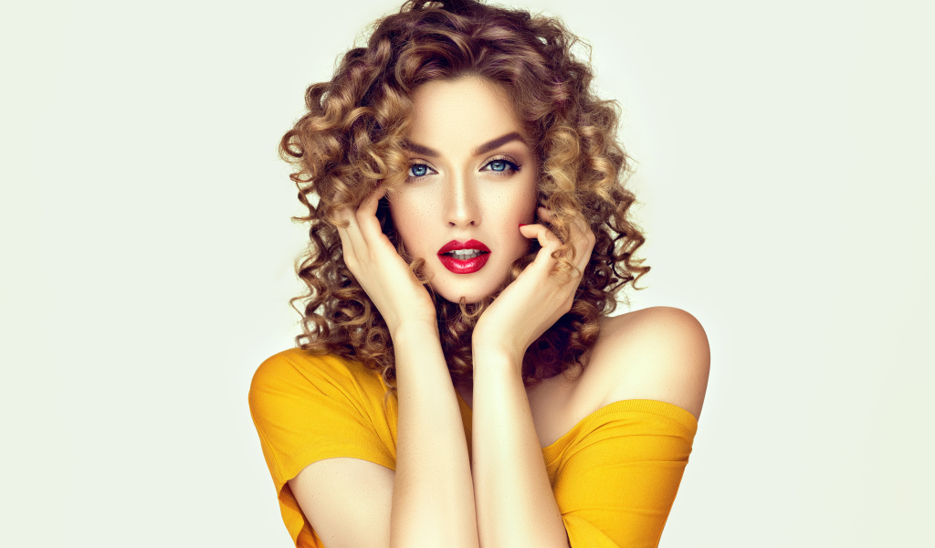 Красивая голубоглазая девушка с кудрявыми волосами в желтом платье 