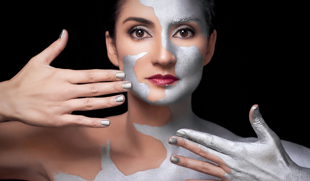 Красивая кареглазая женщина с серебристой краской на теле 