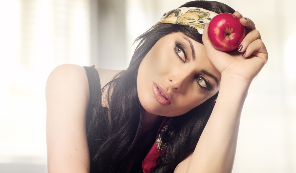 Красивая брюнетка с яблоком в руке 