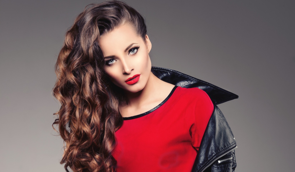 Красивая девушка в черной кожаной куртке и красном свитере