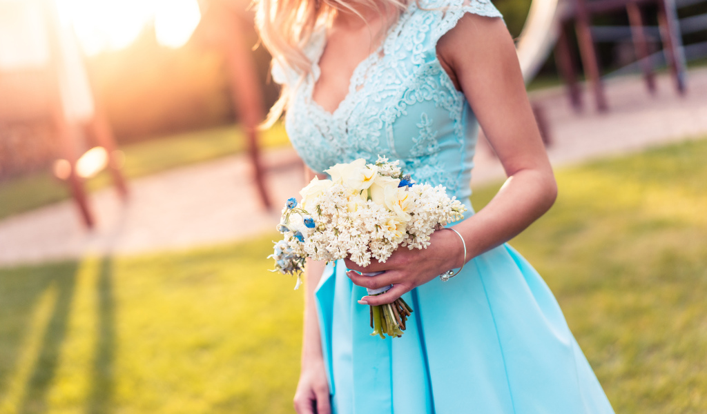 Красивая девушка в голубом платье с букетом в руке