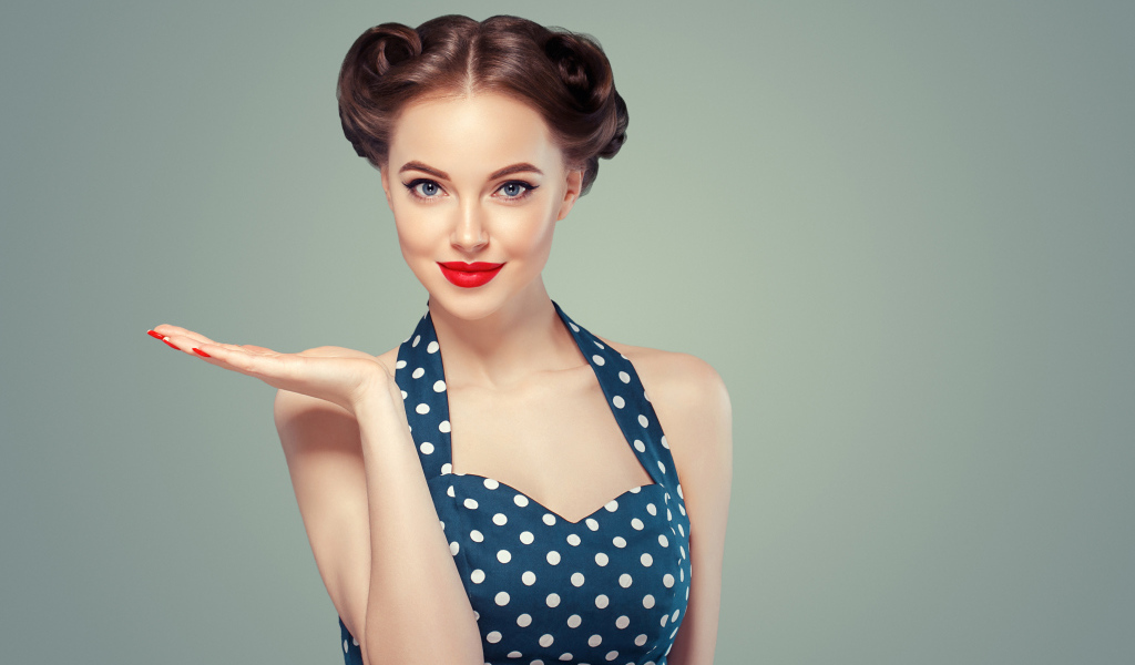 Красивая девушка в платье в горошек на сером фоне