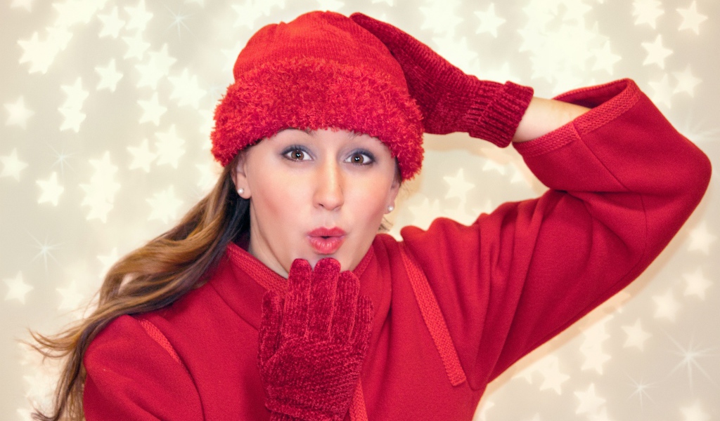 Красивая девушка в красном шлет воздушный поцелуй