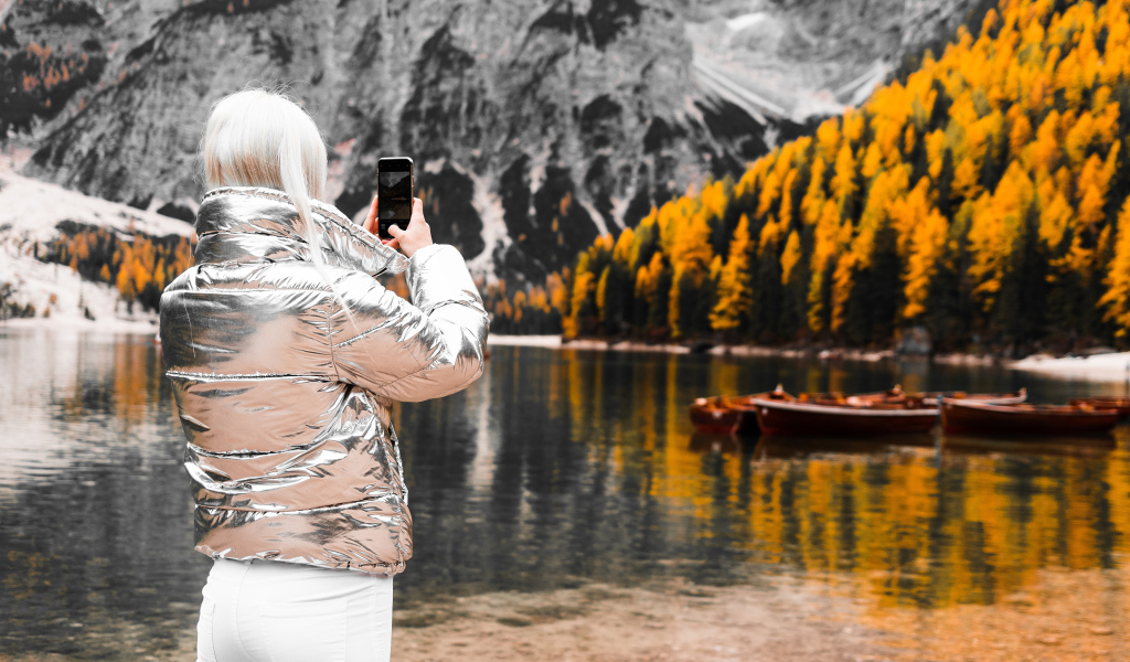 Красивая девушка делает фото гор на телефон 
