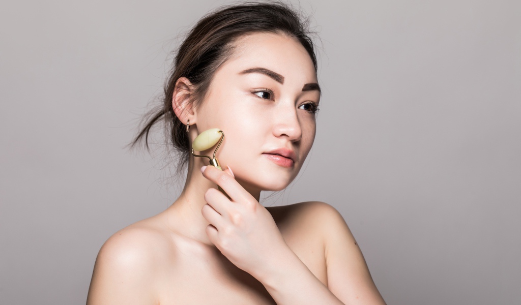 Красивая девушка разглаживает кожу лица