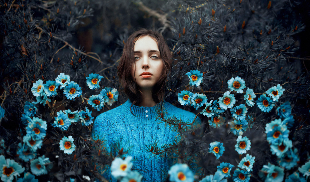 Красивая девушка колючих зарослях с голубыми цветами