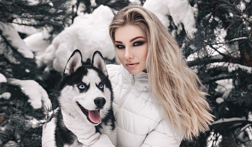 Красивая девушка с хаски у заснеженной ели