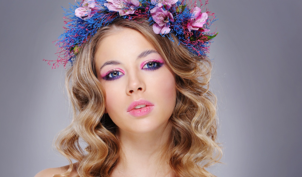 Красивая девушка с нежным макияжем с венком на голове на сером фоне